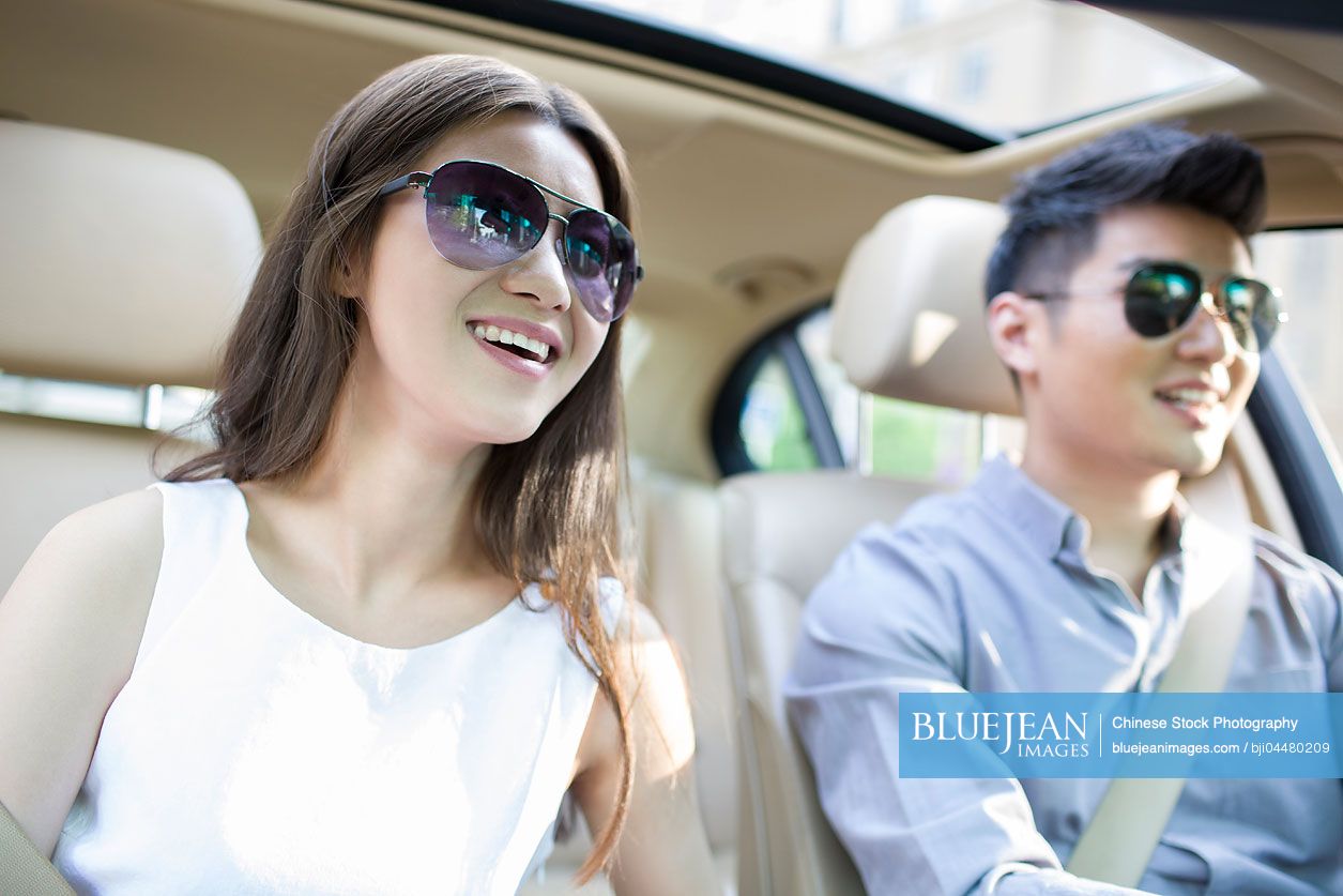 Happy young Chinese couple in a car