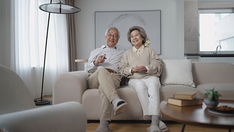 Cheerful senior Chinese couple watching TV at home,4K